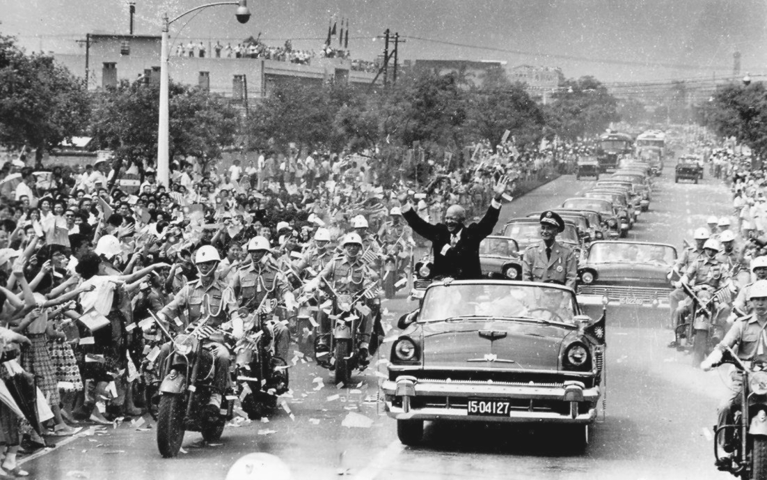 Eisenhower y Chiang Kai shek circulando juntos en un coche descapotable con escolta policial