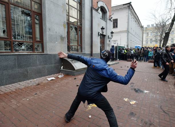 Un manifestante lanza una piedra contra un centro de Rossotrudnichestvo en Kiev, el 18 de febrero de 2018