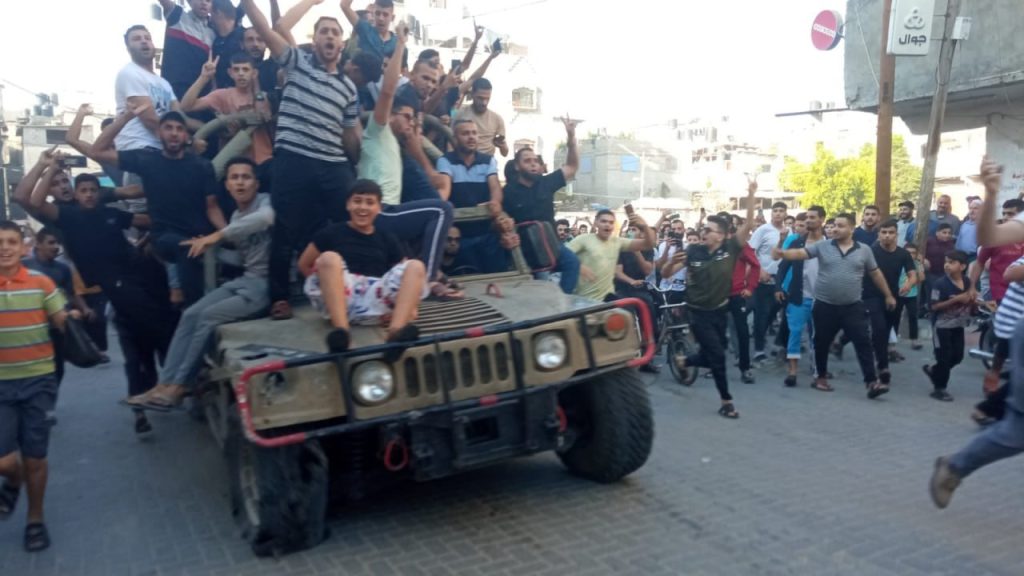 Hamas declara la guerra a Israel. Palestinos celebran la toma de un vehículo militar israelí. 