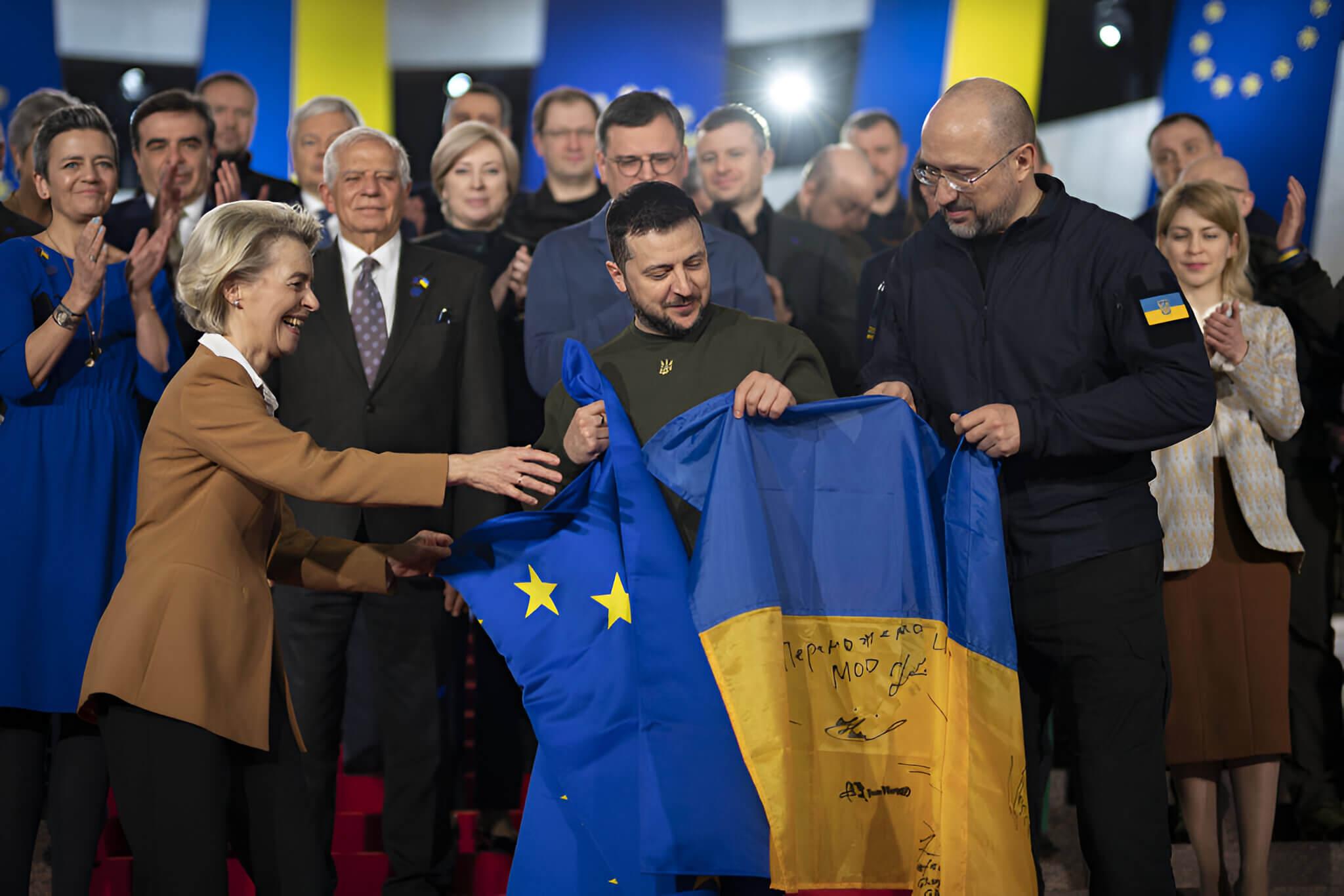 Úrsula von der Leyen, Volodímir Zelenski y Denis Shmihal sostienen banderas de Ucrania y la Unión Europea durante una reunión celebrada en Kiev en febrero de 2023. 