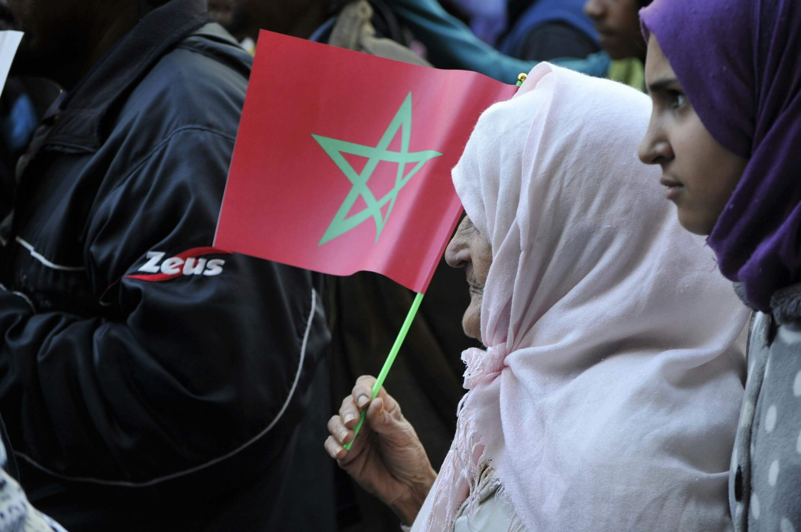 Una señora sostiene una bandera de Marruecos. 