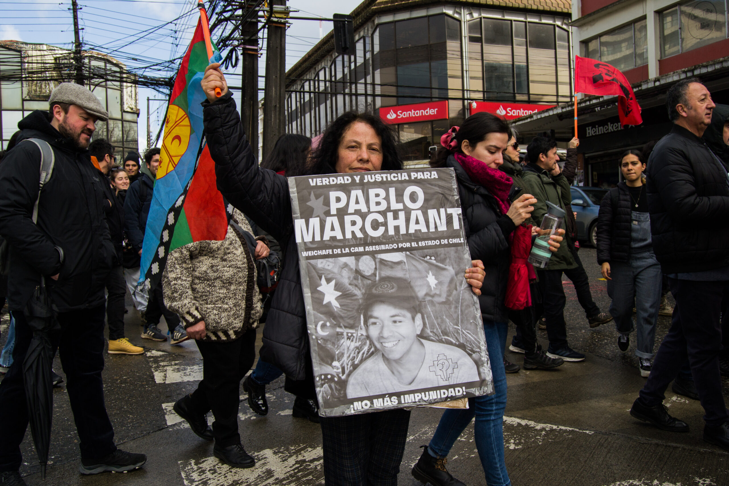 Una manifestante sostiene un cartel en el que exige justicia por la muerte de Pablo Marchant, joven militante mapuche de la Coordinadora Arauco Malleco, que recibió un disparo en la cabeza en 2021 durante un enfrentamiento con las fuerzas policiales